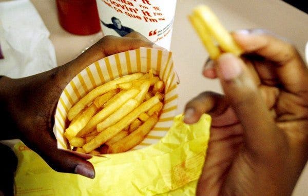 Una mujer sin identificar come patatas fritas en el restaurante de McDonald. Efesalud.com