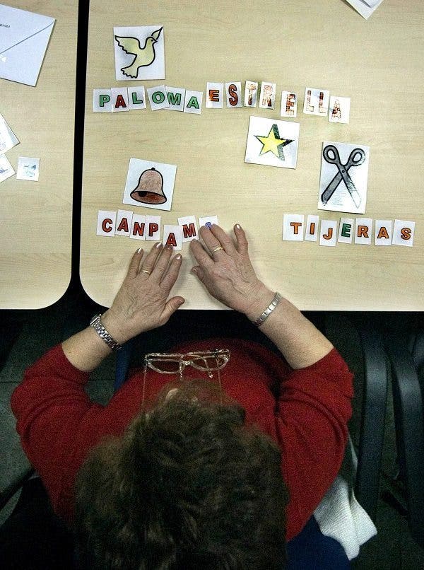 Una enferma de alzheimer asocia palabras e imágenes en uno de los talleres del centro de día "La Pineda" en Castellón. Efesalud.com