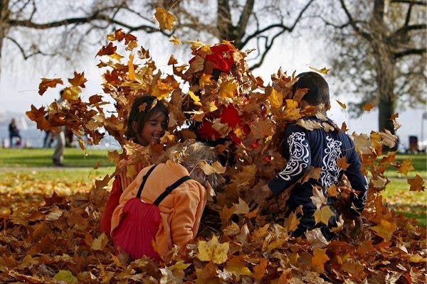 Niños se divierten con las hojas caídas de los árboles en un parque de Zurich.EFE/Alessandro Della Bella