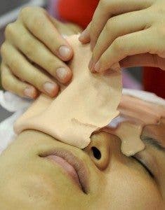 Mujer retirándose una mascarilla facial