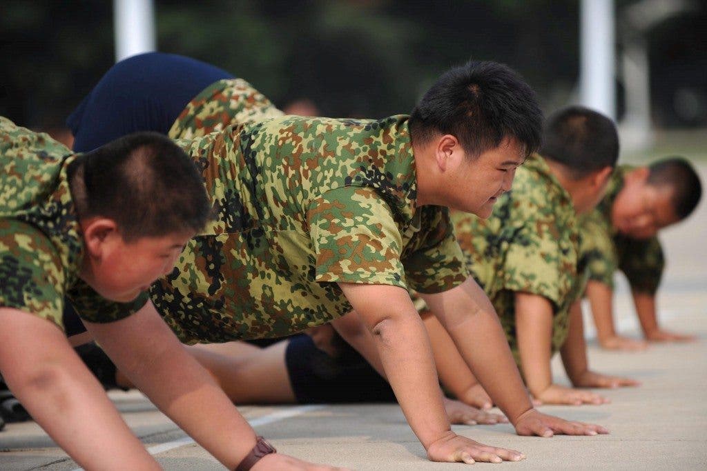 Niños con sobrepeso hacen flexiones durante su participación en un campamento de verano para perder peso en Shenyang, en la provincia nororiental china de Liaoning. EFE
