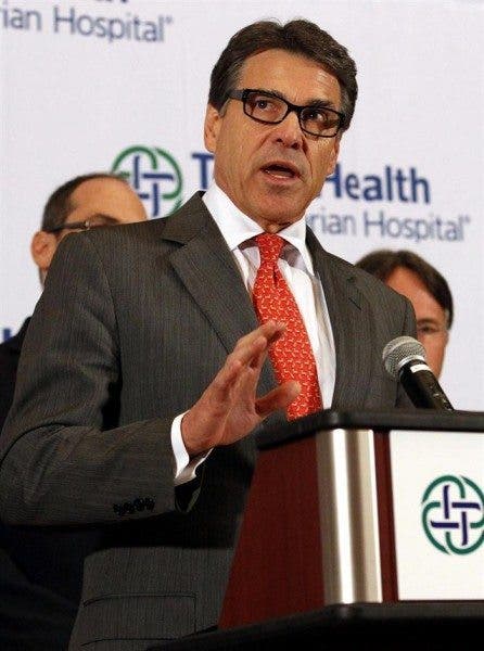 Imagen cercana del gobernador de Texas, Rick Perry, hablando en rueda de prensa en un atril.