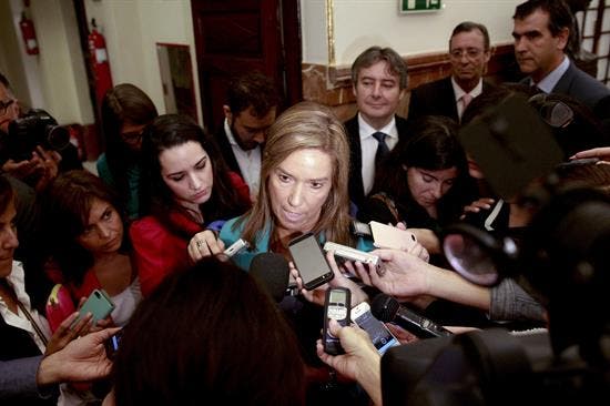 Imagen desde arriba de Ana Mato, ministra de Sanidad, en los pasillos del Congreso rodeada de periodistas, micrófonos y cámaras