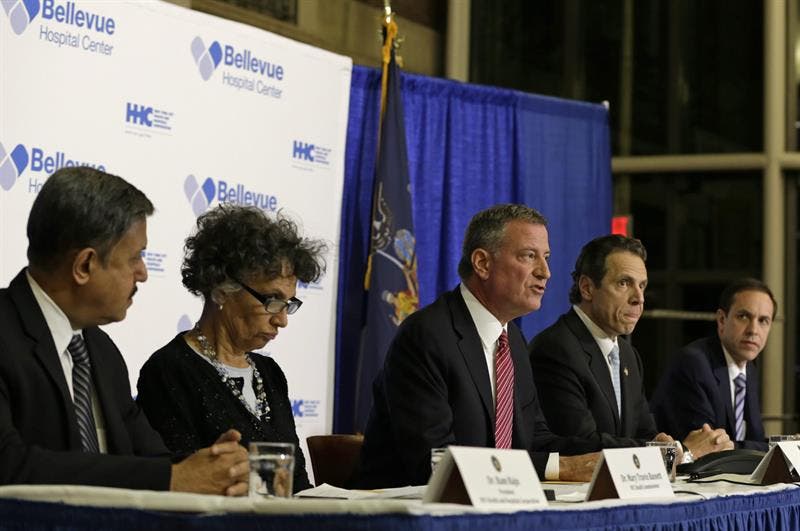 Cinco autoridades de Nueva York, entre ellos el alcalde, Bill de Blasio, sentados en una mesa alargada ofrecen una rueda de prensa.