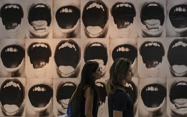 Dos jóvenes pasean delante de una obra en la feria de arte ArtRio, en Río de Janeiro (Brasil). Efesalud.com