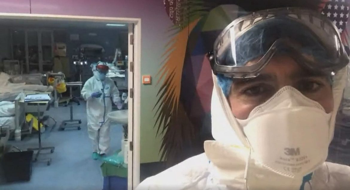 Un enfermero de UCI, vestido de nivel 1 con su Equipo de Protección Individual (EPI) a las puertas de una Unidad de Cuidados Intensivos