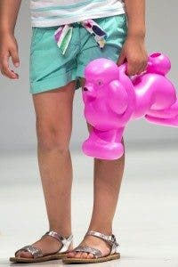 Detalle de una modelo que desfila con un juguete de un caniche rosa. Efesalud.com