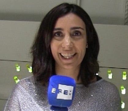 Un primer plano de la médico oncólogo, Lara Iglesias, quien sujeta el micrófono azul con el logotipo de la Agencia EFE