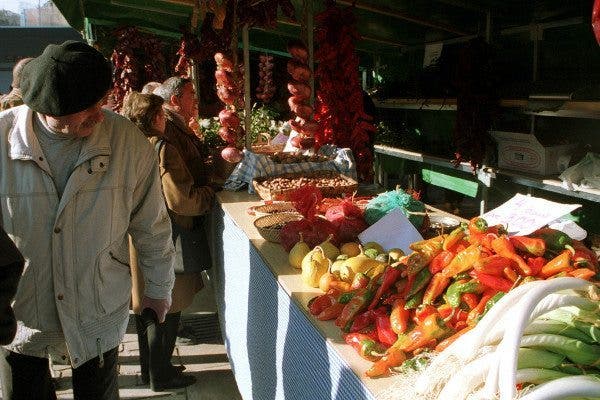 Hombre mayor con boina en un mercado de verduras y frutas. Efesalud.com