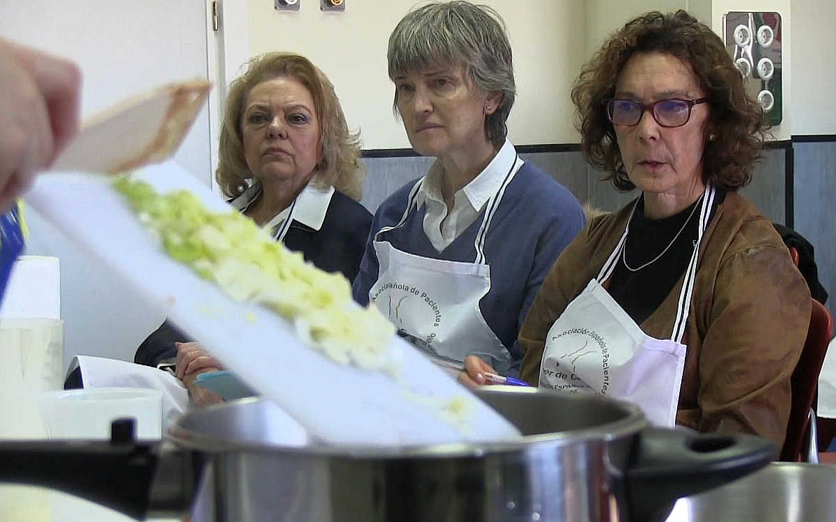 Mayra y otras dos pacientes, María Inmaculada a la derecha, prestan atención a la elaboración del "Puré Zalés".