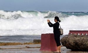 LA HABANA (CUBA) 23/01/2016.- Una mujer toma fotos del oleaje en una zona baja del litoral norte en La Habana (Cuba). EFE/Ernesto Mastrascusa