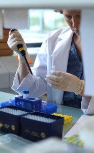 Investigadora analizando muestras oncológicas en un laboratorio.