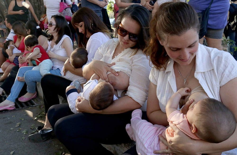 Varias mujeres, sentadas las unas junto a las otras en un acto público vindicativo, amamantan a sus bebés en Paraguay