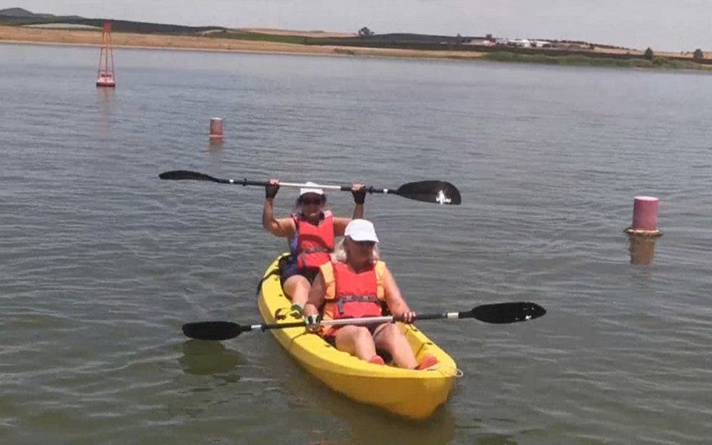 Dos mujeres practican canoa en un lago durante el verano