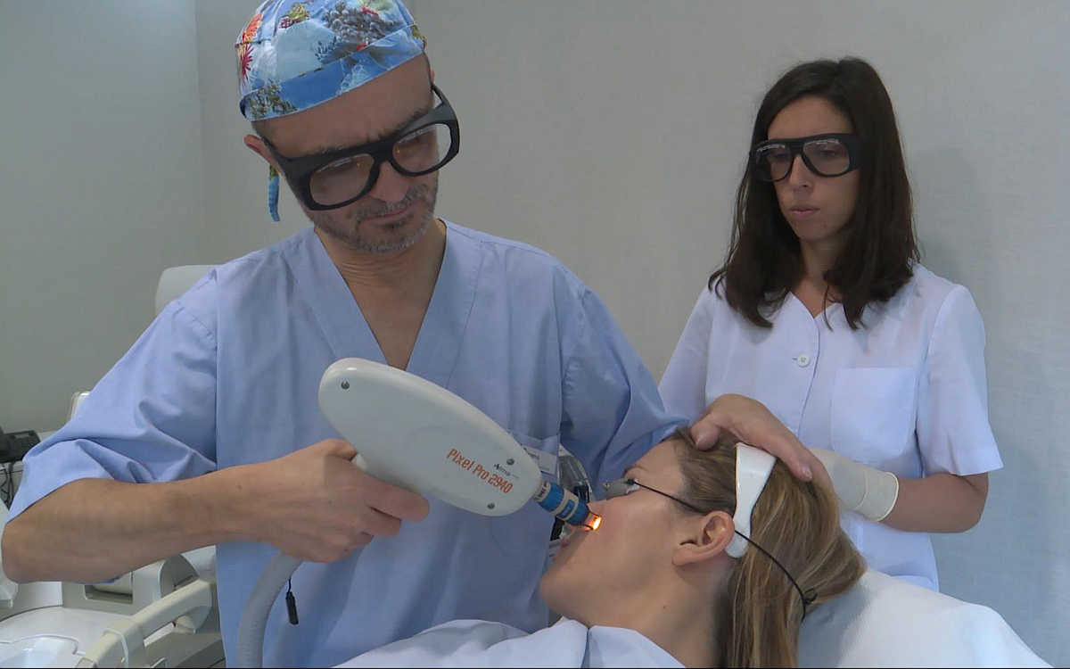 el doctor Eduardo López Bran elimina las cicatrices del acné con tecnología láser a una paciente joven en presencia de su enfermera de la Clínica Imema.