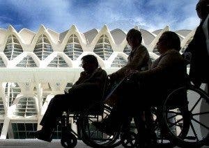 Dos siluetas de personas en silla de ruedas en la Ciudad de las Artes y de las Ciencias de Valencia. Efesalud.com