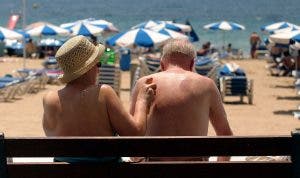 Una pareja de personas mayores sentadas en un banco de la playa-efe