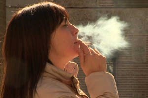 Mujer fumando un cigarrillo.