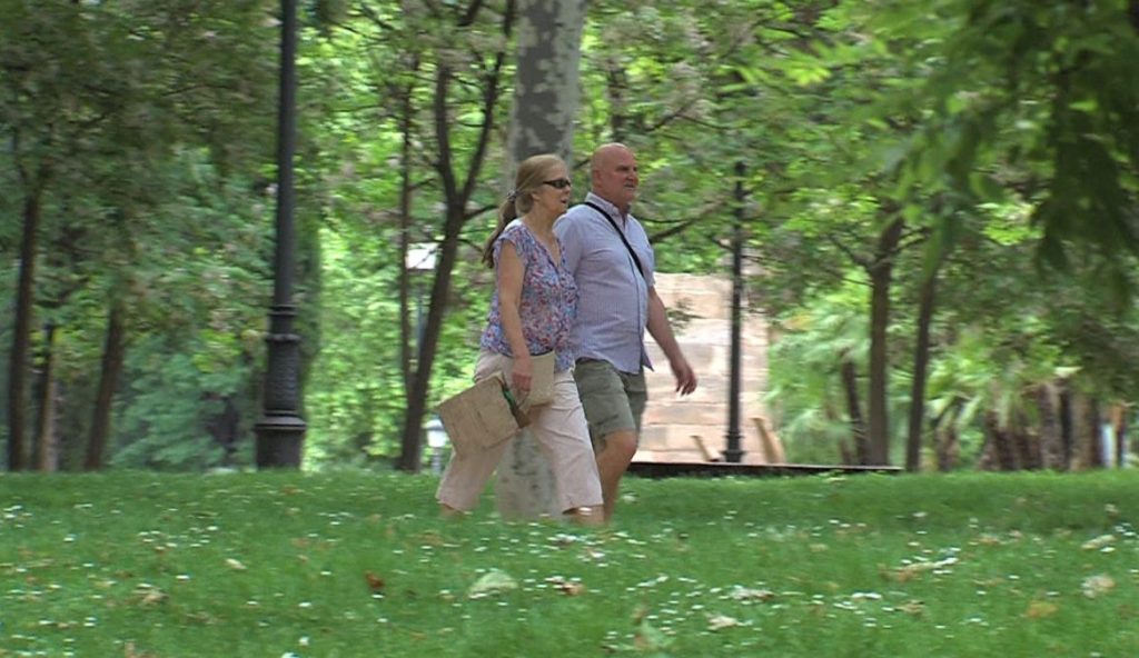 Análisis de orina-hombre y mujer paseando por un parque madrileño.